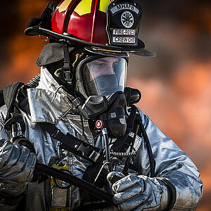 [Translate to Vietnamesisch:] Fire fighter in protection clothing