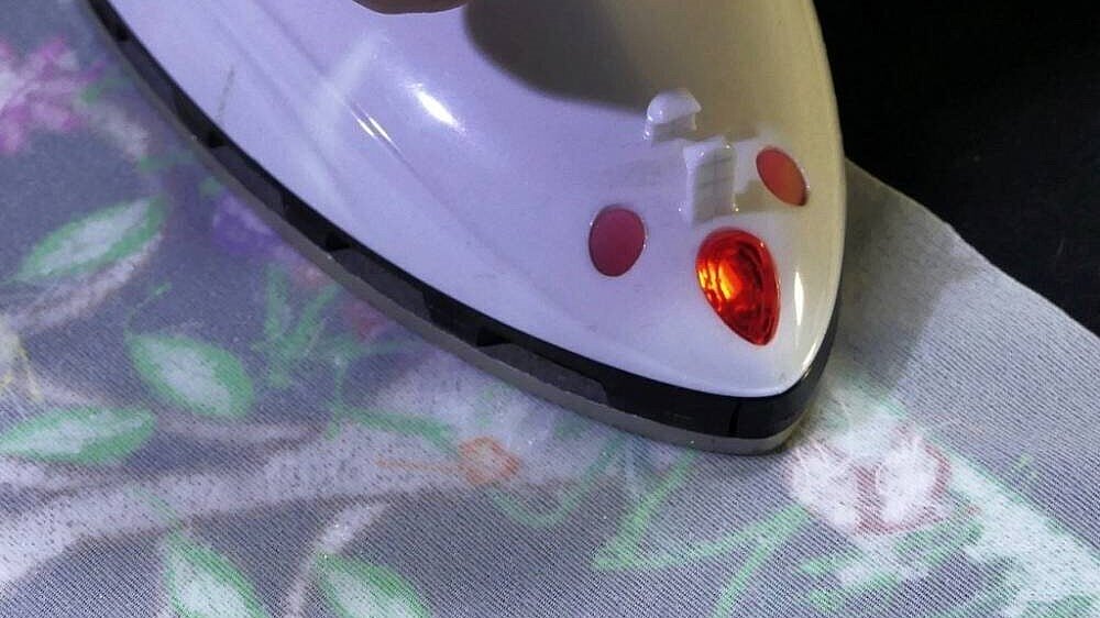 [Translate to Hongkong (Englisch):] image showing a comfort wear embroidery inlay being ironed onto a fabric 