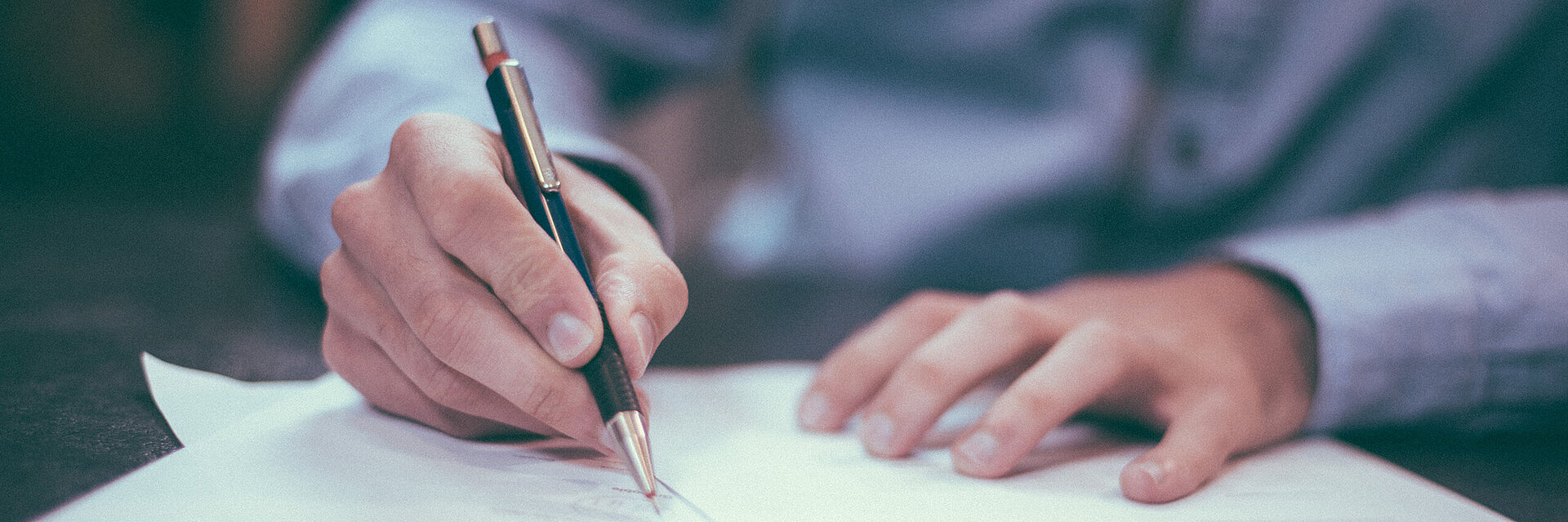 [Translate to Hongkong (Englisch):] Businessman writing on a paper