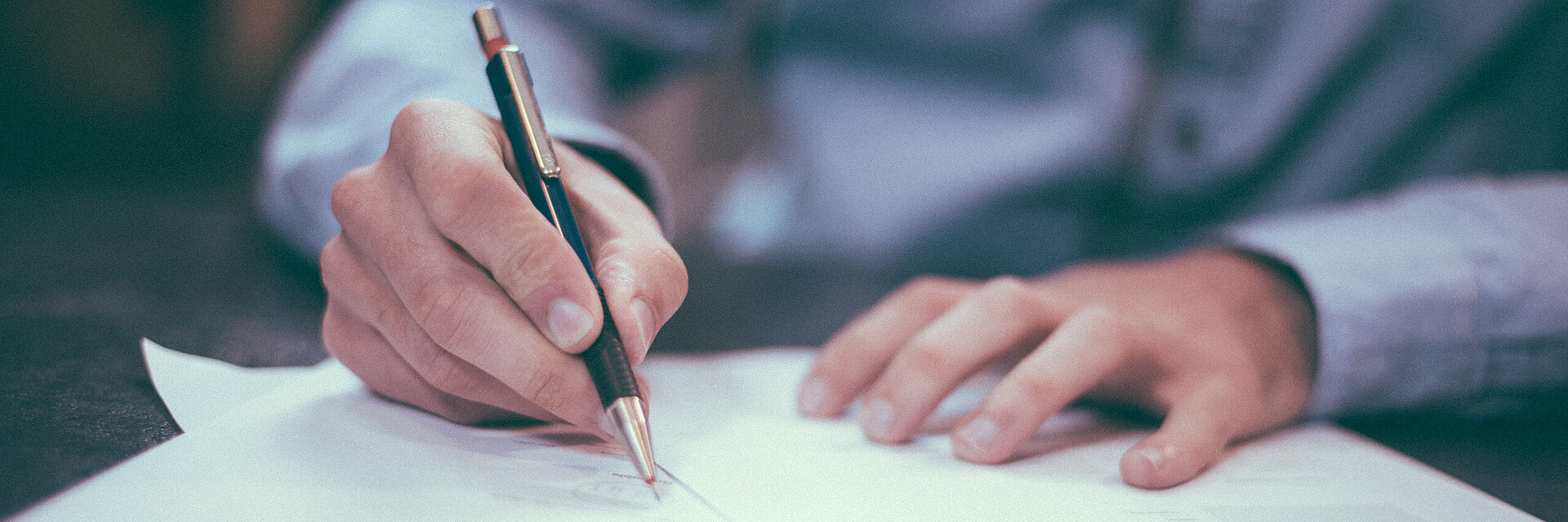 [Translate to Vietnamesisch:] Businessman writing on a paper