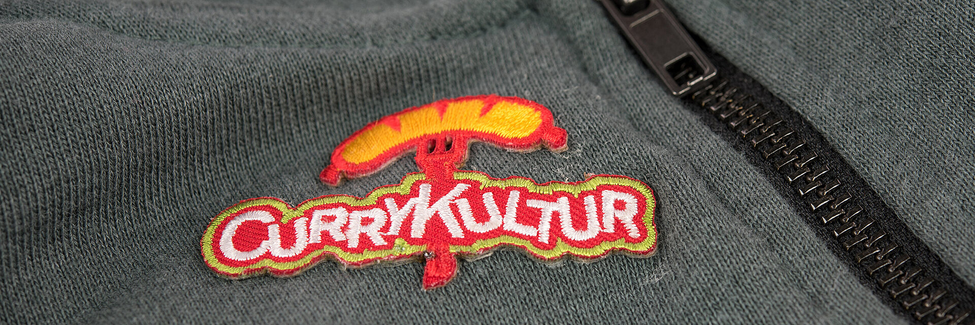 [Translate to Vietnamesisch:] embroidered fast food logo "Currykultur"