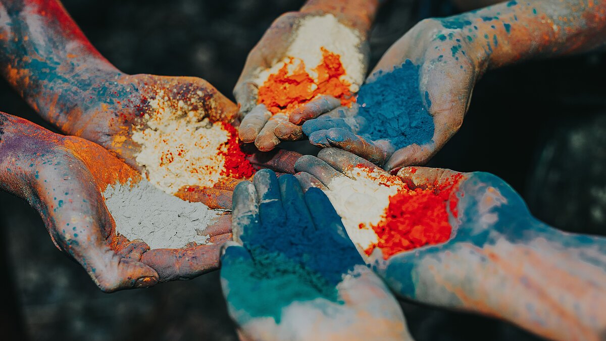 3 pairs of hands covered with colour powder