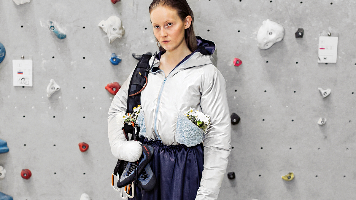 [Translate to Hongkong (Englisch):] Girl in embroidered outdoor fashion clothes in front of hiking wall